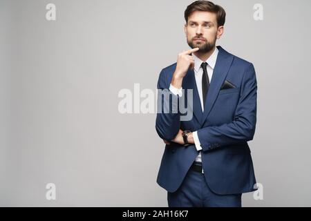 Studuo shot of thinking businessman wearing suit Stock Photo