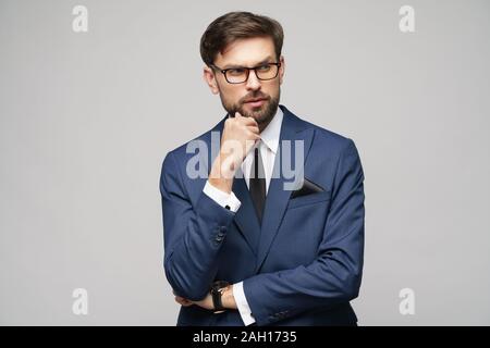 Studuo shot of thinking businessman wearing suit Stock Photo