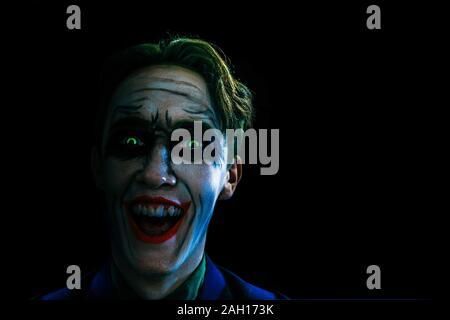 Bloody Halloween theme. The crazy joker face on black background. Comics heroes. Copy space for text. Stock Photo