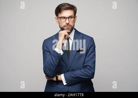 Studuo shot of thinking businessman wearing suit Stock Photo