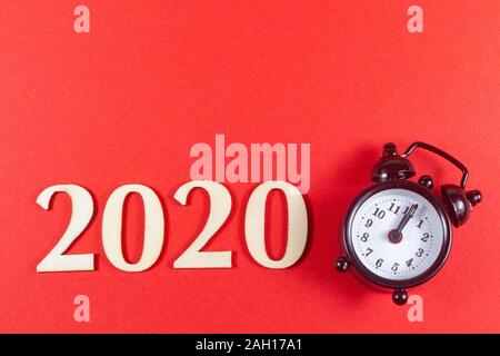 2020 and black alarm clock on red background Stock Photo
