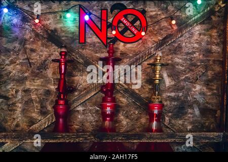 Three hookahs on the shelf under the inscription not to smoke Stock Photo