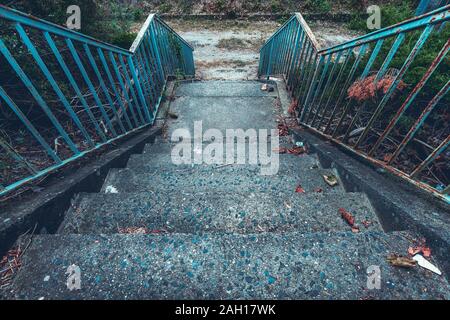 old concrete staircase with rusty blue railing Stock Photo