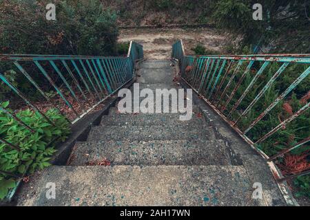 old concrete staircase with rusty blue railing Stock Photo