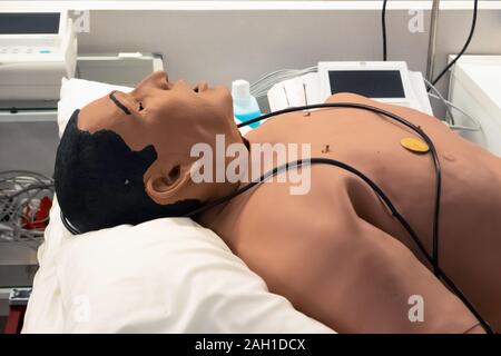Defibrillator on a dummy doll for practice. Cpr dummy for training purposes in hospital. First aid training class for medical students Stock Photo