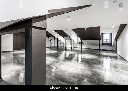 Empty unfurnished loft mansard room interior with wooden columns and wet concrete floor on roof level in black and whote style color Stock Photo