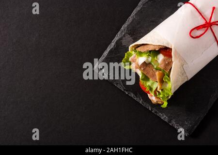 Doner kebab or shawarma sandwich on black slate background.Top view. Copy space Stock Photo
