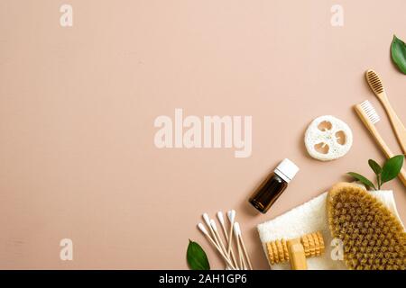 Flat lay composition with eco natural bamboo toothbrushes, luffa sponge, essential oil, ear sticks, bathroom brush and green leaves. Zero waste, plast Stock Photo