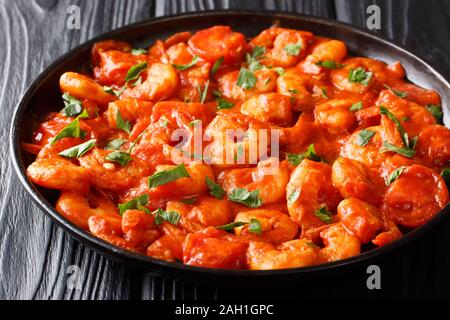 prawns with garlic and herbs in tomato sauce close-up in a plate on the table. horizontal Stock Photo