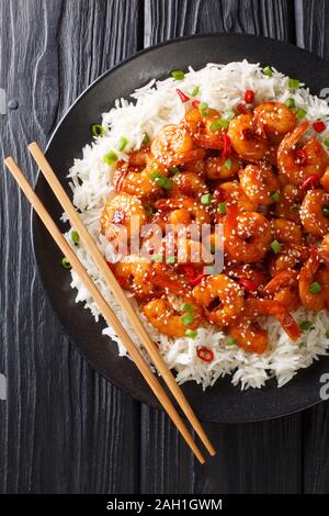 Asian Chilli Garlic Prawns Shrimp with rice side dish close-up in a plate on the table. Vertical top view from above Stock Photo