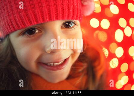 Happy little girl and Christmas lights on background. Happy new year.
