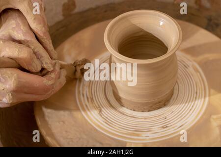 Master class on modeling of clay on a potter's wheel. Unburn pottery jar Stock Photo