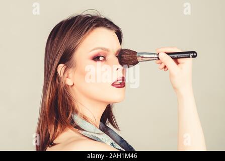 Professional makeup supplies. Different brushes. Skin care. Makeup cosmetics concept. Skin tone concealer. Cosmetics shop. Girl apply eye shadows. Woman applying makeup brush. Emphasize femininity. Stock Photo
