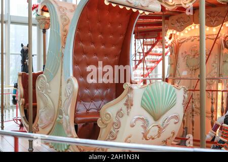 Closeup of passenger chair in a vintage Carousel in a holiday park. Merry-go-round with horses. Stock Photo