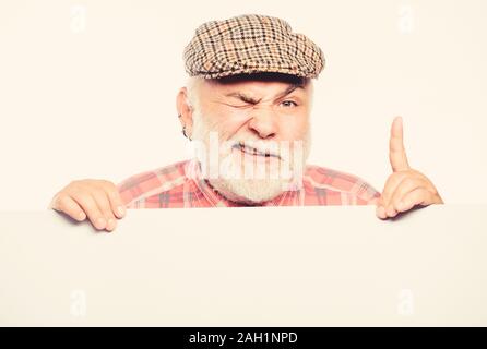 Elderly person. Senior bearded emotional man peek out of banner place announcement. Pensioner grandfather in vintage hat poster information copy space. Announcement concept. Event announcement. Stock Photo
