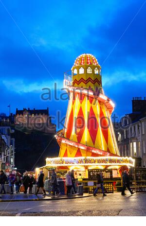 Edinburgh, Scotland, UK. 23rd  Dec 2019. Helter Skelter Christmas funfair in Castle Street as dusk approaches. View of Edinburgh Castle. Credit: Craig Brown/Alamy Live News Stock Photo