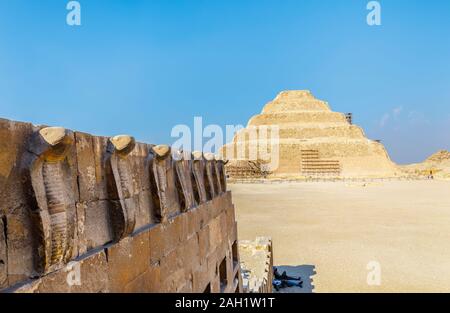Cobra frieze on the South Tomb Chapel and the Step Pyramid of Djoser in Saqqara, necropolis for the ancient Egyptian capital, Memphis, Egypt Stock Photo