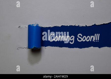 Coming Soon! write on blue and white torn paper Stock Photo