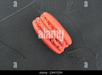 Delicious pink macaroon on concrete background, top view Stock Photo