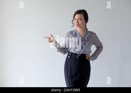 Portrait of a beautiful fashionable Asian woman in a business suit shows hand Stock Photo