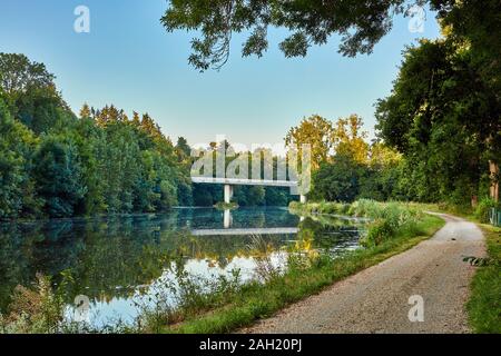 Image of La Villaine River with the D38 bridge, trees and towpath Stock Photo