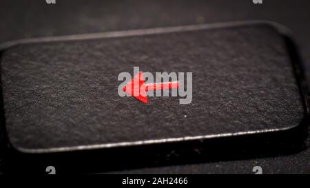 A red arrow button on a black keyboard of a computer Stock Photo
