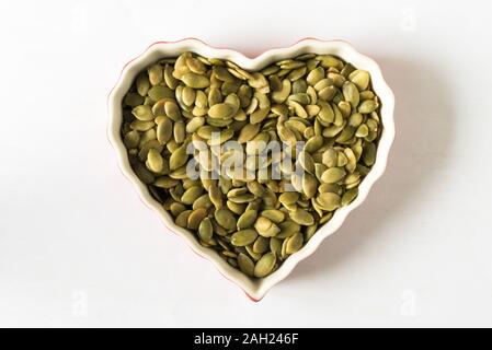 Green Pumpkin Seeds - Pepita in a Heart Shape Stock Photo