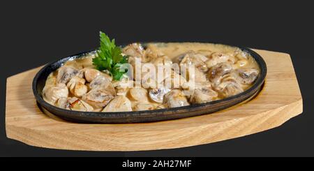 stewed mushrooms (champignons) in sour cream and a sprig of parsley Stock Photo