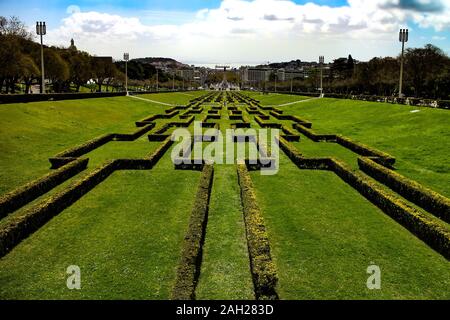Symmetric gardening in the 'Parque Eduardo VII de Inglaterra' park and view towards the sea and city center in Lisbon, Portugal. Stock Photo