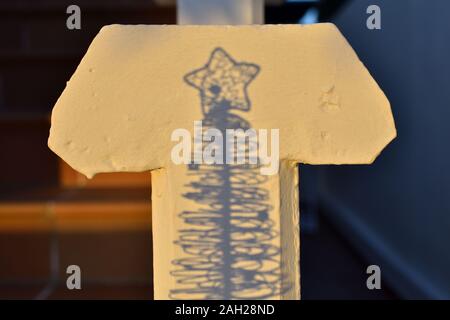 The beginning and the end: Shadow of a small Christmas tree on a cross-shaped balustrade Stock Photo