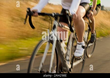 Mature couple cycling along a country road Stock Photo