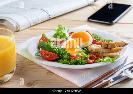 Healthy business breakfast in european or american style with boiled eggs, vegetables and herbs. Close up Stock Photo