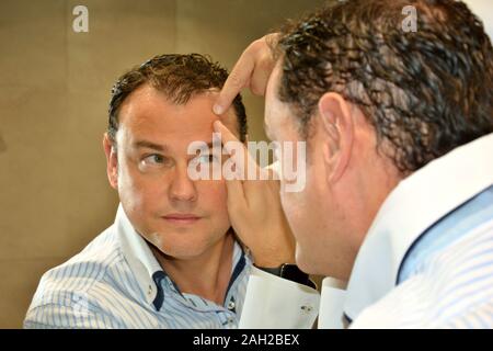 one person looking at himself in the mirror Stock Photo