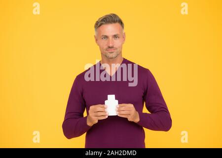 Body odor care. Handsome man hold lotion or bodywash bottle. Presenting personal hygiene care product. Shampoo or gel for hair care. Skin and body care. Cologne or deodorant, copy space. Stock Photo