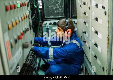 Marine engineer inspecting ship's engine or generators Stock Photo