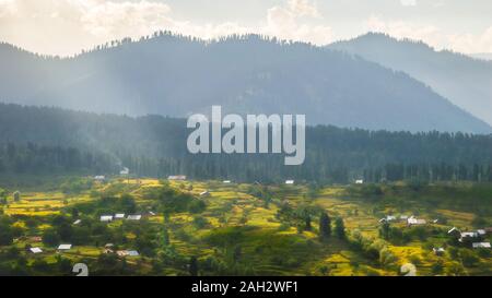 Sun light beams falling on the landscape creating interesting patches of light and dark areas Stock Photo