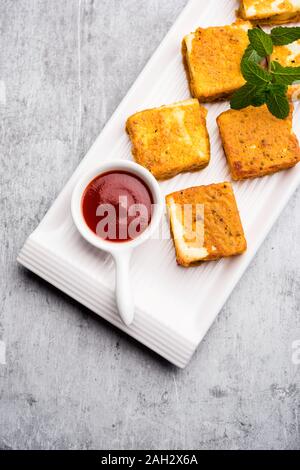 Amritsari Paneer Tikka made using cottage cheese cubes dipped in a batter made with besan, chat masala and spices and shallow fried in pan, served wit Stock Photo