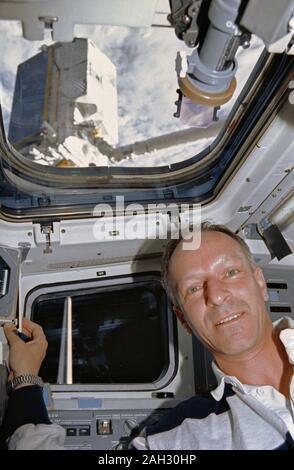 (1 Aug 1992) --- Claude Nicollier, representing the European Space Agency (ESA) onboard the Space Shuttle Atlantis for the mission, is seen on the flight deck during pre-deployment operations with the ESA's EURECA satellite.  EURECA can be seen on the end of the Remote Manipulator System (RMS).  Nicollier was joined by five NASA astronauts and an Italian payload specialist for eight days aboard the Atlantis. Stock Photo