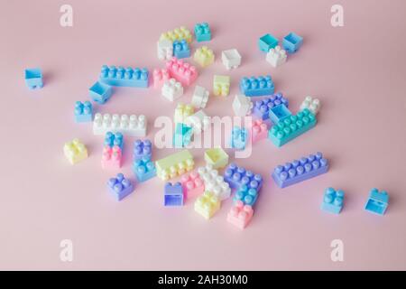 Plastic building blocks toy on pastel pink background minimal creative concept. Stock Photo