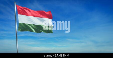 The National flag of Hungary blowing in the wind in front of a clear blue sky Stock Photo