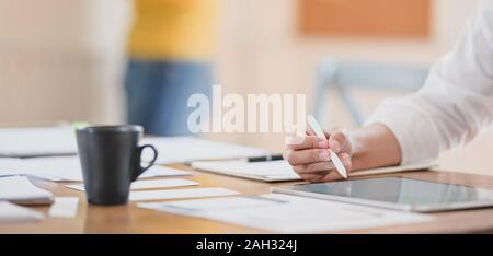 Close-up view of young hard-working ui web designer working on her concept with tablet Stock Photo