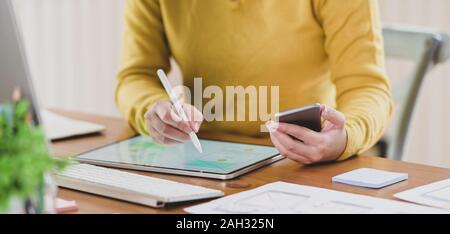 Cropped shot of young professional ux web developer working on her project while using digital tablet Stock Photo
