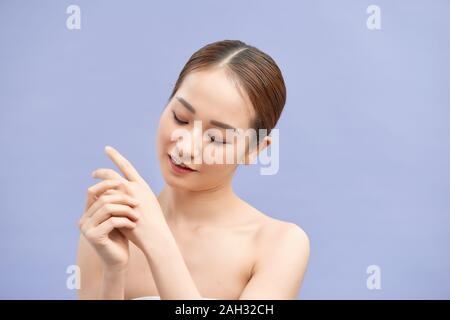 Young beautiful woman applying hands cream Stock Photo
