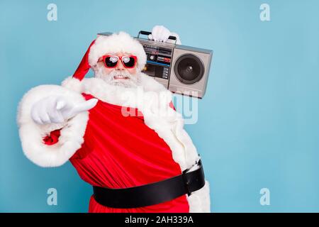 Close-up pf his he nice cool fat cheerful cheery glad bearded Santa clubber carrying tape player pointing at you invite welcome to nightclub isolated Stock Photo
