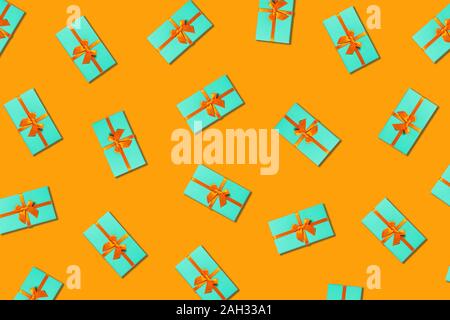 Pattern with group of mint holiday boxes on orange background. Flat lay, top view. Stock Photo