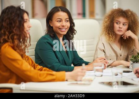 Three charming multi-ethnic businesswomen having meeting in board room horizontal shot Stock Photo