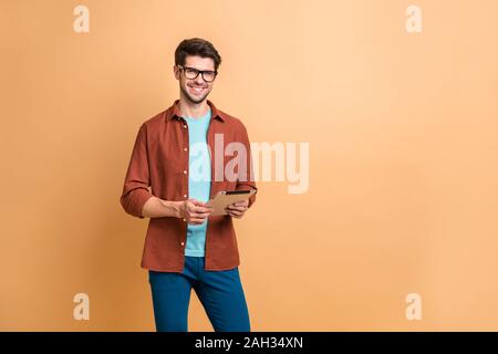 Portrait of his he nice attractive cheerful cheery successful content brunette guy holding in hands digital e-book browsing web app isolated over Stock Photo