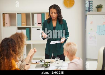 Attractive African American businesswoman presentin at meeting, her colleagues clapping hands Stock Photo