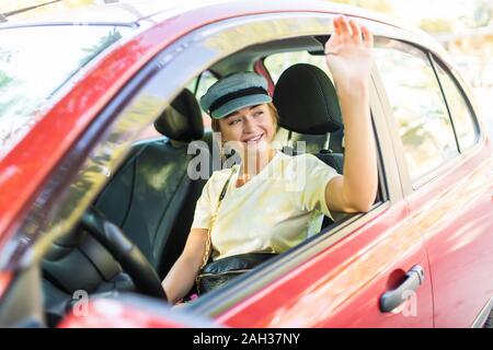 Caucasian car driver woman greets Stock Photo