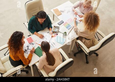 Horizontal top shot of five successful women creating new fashionable clothes collection Stock Photo